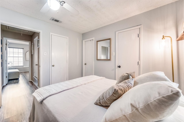 1161 Dallas Dr, Denton, TX 76205 - bedroom with attic access, wood finished floors, a textured ceiling, and a ceiling fan