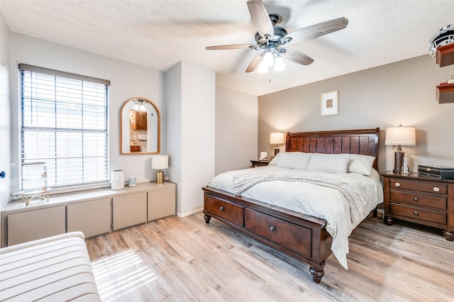 1161 Dallas Dr, Denton, TX 76205 - bedroom featuring light wood-style flooring, a textured ceiling, and ceiling fan