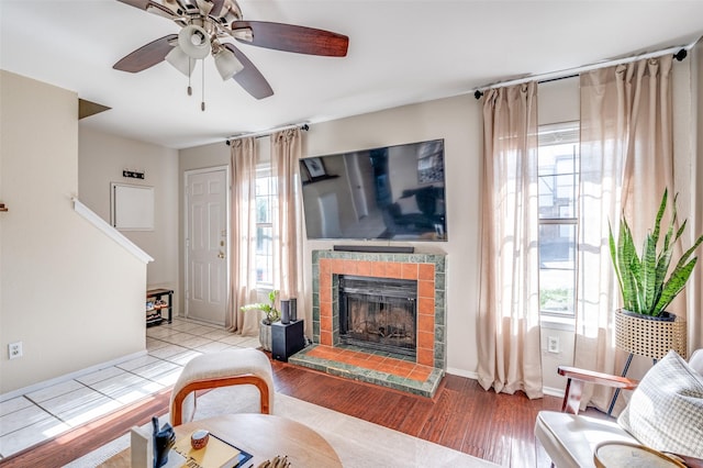 1161 Dallas Dr, Denton, TX 76205 - living room featuring healthy amount of natural light, a tile fireplace, wood finished floors, and ceiling fan