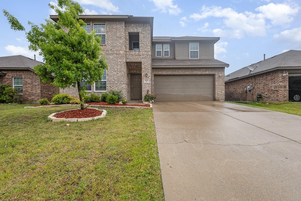 9430 Smoke Tree Dr, Forney, TX 75126 - traditional home with concrete driveway, a garage, a front yard, and brick siding