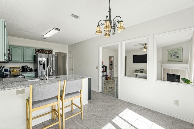 1512 La Paz Dr, Plano, TX 75074 - kitchen featuring green cabinetry, range, stainless steel fridge, a peninsula, and a ceiling fan