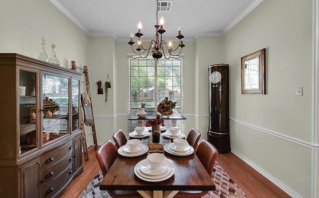 11001 Ridge Point Dr, Woodway, TX 76712 - dining area featuring healthy amount of natural light, a textured ceiling, wood finished floors, a chandelier, and crown molding