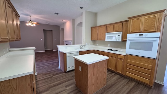 2217 Lone Pecan Dr, Garland, TX 75040 - kitchen featuring white appliances, arched walkways, a kitchen island, dark wood-type flooring, and a ceiling fan