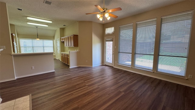 2217 Lone Pecan Dr, Garland, TX 75040 - unfurnished living room featuring dark wood finished floors, a textured ceiling, ceiling fan, and lofted ceiling