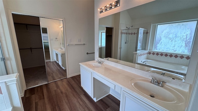 2217 Lone Pecan Dr, Garland, TX 75040 - bathroom with a shower stall, wood finished floors, double vanity, a bath, and a spacious closet