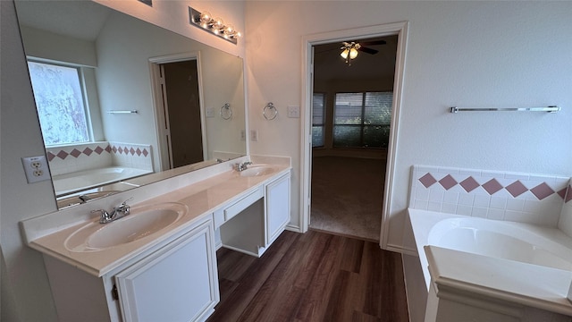 2217 Lone Pecan Dr, Garland, TX 75040 - bathroom with a garden tub, double vanity, wood finished floors, and a ceiling fan
