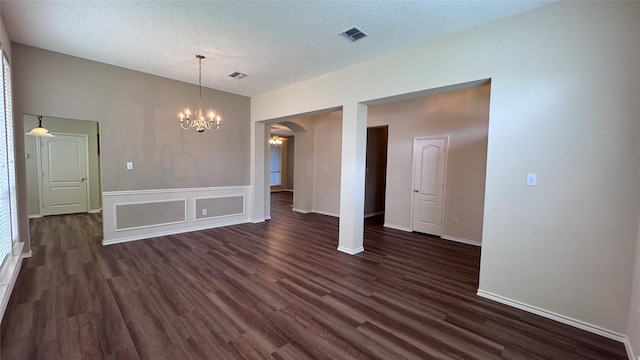 2217 Lone Pecan Dr, Garland, TX 75040 - unfurnished dining area with a chandelier, arched walkways, dark wood-style flooring, and a textured ceiling