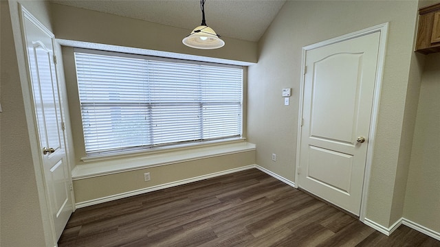 2217 Lone Pecan Dr, Garland, TX 75040 - unfurnished dining area featuring dark wood-type flooring, lofted ceiling, and a textured ceiling