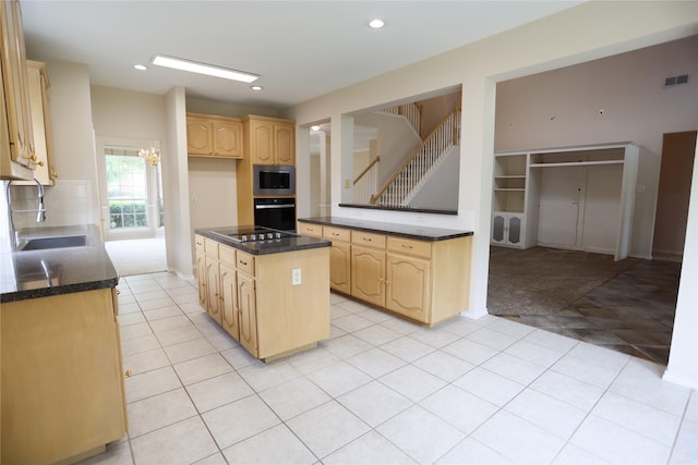 2325 Denham Dr, Arlington, TX 76001 - kitchen with stainless steel microwave, light brown cabinetry, oven, a kitchen island, and tasteful backsplash