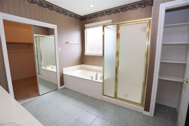 2325 Denham Dr, Arlington, TX 76001 - bathroom featuring a walk in closet, a bath, a stall shower, tile patterned floors, and wallpapered walls