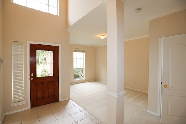 2325 Denham Dr, Arlington, TX 76001 - entrance foyer featuring light carpet, crown molding, decorative columns, and light tile patterned flooring