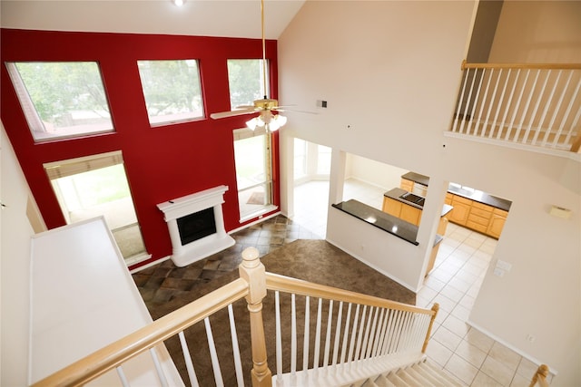 2325 Denham Dr, Arlington, TX 76001 - stairs featuring high vaulted ceiling, tile patterned floors, a fireplace with raised hearth, and a ceiling fan
