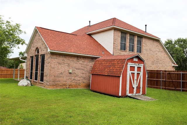 2325 Denham Dr, Arlington, TX 76001 - back of house featuring a shingled roof, a fenced backyard, a storage unit, and brick siding