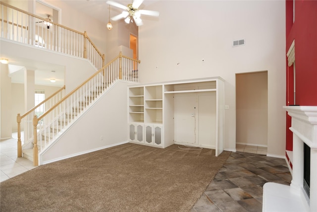 2325 Denham Dr, Arlington, TX 76001 - unfurnished living room with a high ceiling, a ceiling fan, stairway, carpet, and tile patterned floors