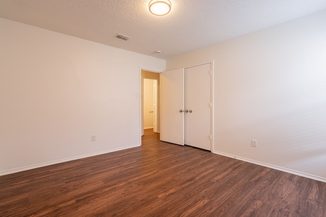 233 Stoneridge Dr, Mesquite, TX 75149 - spare room featuring dark wood-type flooring and a textured ceiling