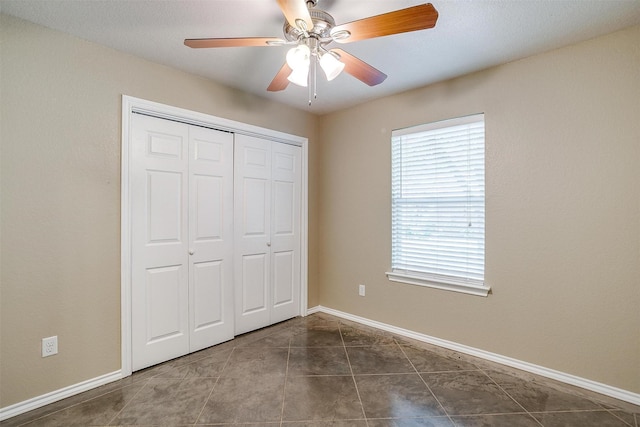 1414 Cheyenne Trl, Granbury, TX 76048 - unfurnished bedroom with a closet, dark tile patterned floors, and ceiling fan
