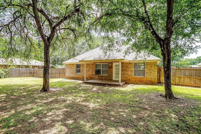 1414 Cheyenne Trl, Granbury, TX 76048 - back of house featuring a fenced backyard, brick siding, a patio area, and a shingled roof