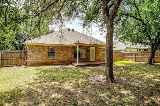 1414 Cheyenne Trl, Granbury, TX 76048 - back of property featuring a fenced backyard, a patio, brick siding, and a shingled roof