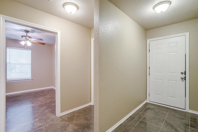 1414 Cheyenne Trl, Granbury, TX 76048 - foyer entrance featuring a textured wall, dark tile patterned flooring, a textured ceiling, and a ceiling fan