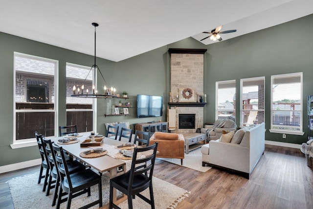 1415 Misty Pasture Way, Mansfield, TX 76063 - dining room featuring a stone fireplace, a chandelier, wood finished floors, ceiling fan, and vaulted ceiling