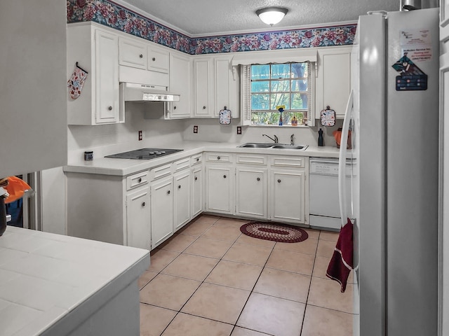 2641 Woodmont Cir, Waco, TX 76710 - kitchen with white appliances, white cabinets, under cabinet range hood, light countertops, and a textured ceiling