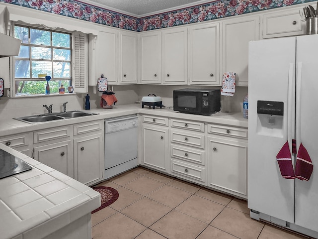 2641 Woodmont Cir, Waco, TX 76710 - kitchen featuring white appliances, tile counters, white cabinets, light tile patterned floors, and a textured ceiling