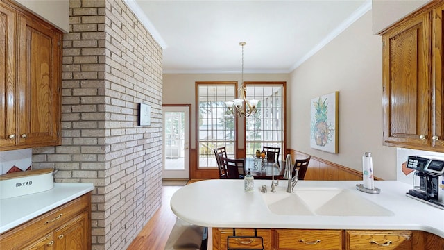 22770 Diamond Bay Dr, Frankston, TX 75763 - kitchen featuring brown cabinetry, light countertops, a chandelier, crown molding, and wood finished floors