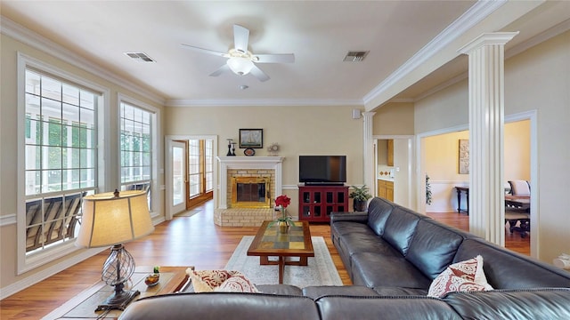 22770 Diamond Bay Dr, Frankston, TX 75763 - living room featuring ornate columns, a ceiling fan, light wood-style floors, crown molding, and a fireplace