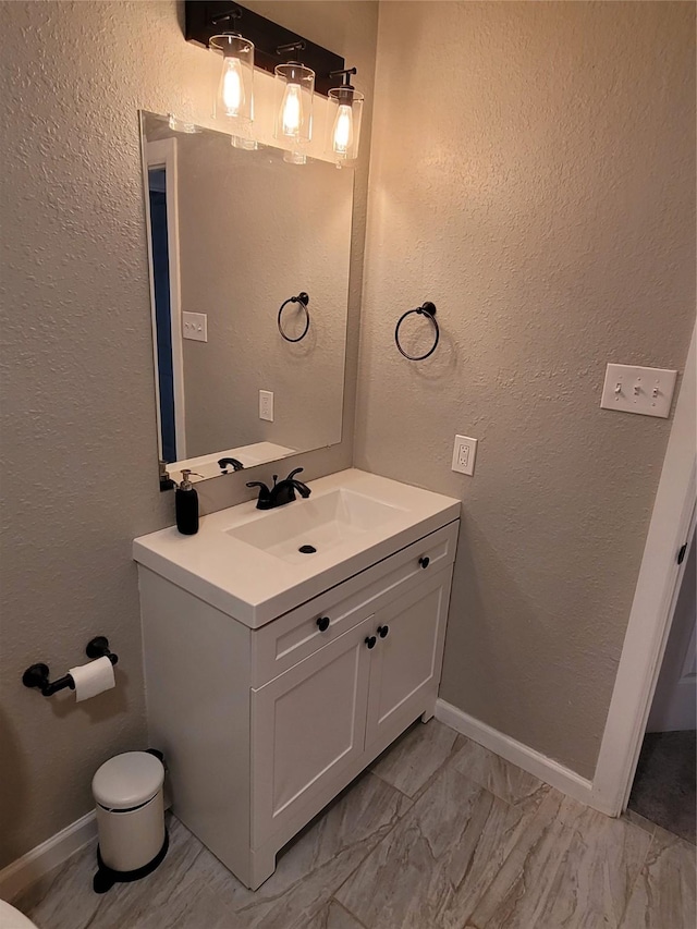 3309 Graybar Dr, Garland, TX 75040 - bathroom featuring vanity, marble look tiles, and a textured wall