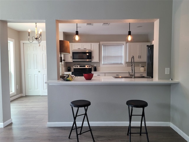 3309 Graybar Dr, Garland, TX 75040 - kitchen featuring stainless steel microwave, electric range, freestanding refrigerator, and white cabinets