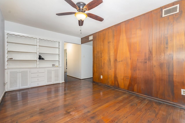 507 Vernet St, Richardson, TX 75080 - spare room featuring wood-type flooring, a ceiling fan, built in shelves, and wood walls