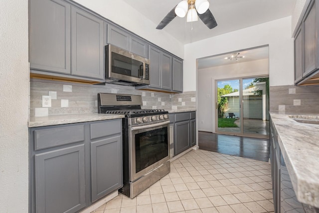 507 Vernet St, Richardson, TX 75080 - kitchen featuring stainless steel appliances, gray cabinetry, light tile patterned floors, and decorative backsplash
