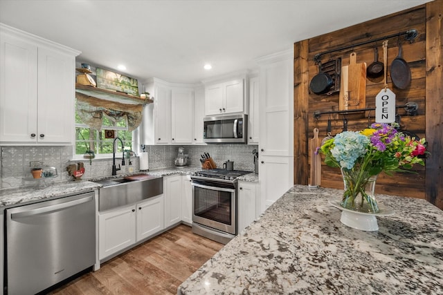 3121 SE County Road 2135, Corsicana, TX 75109 - kitchen featuring appliances with stainless steel finishes, light wood-style floors, white cabinetry, decorative backsplash, and recessed lighting