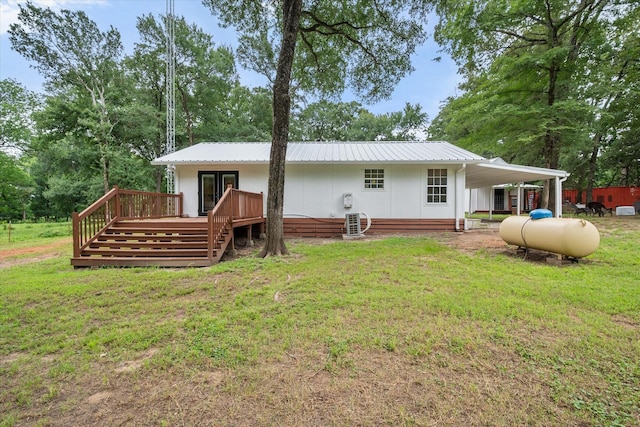 3121 SE County Road 2135, Corsicana, TX 75109 - back of house featuring a wooden deck, a yard, a metal roof, and view of wooded area