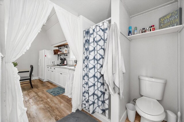 3121 SE County Road 2135, Corsicana, TX 75109 - full bath with vanity, wood finished floors, lofted ceiling, and curtained shower