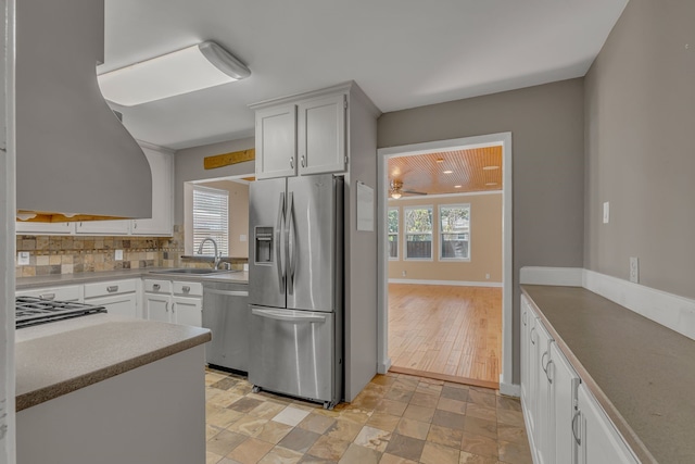11502 Rupley Ln, Dallas, TX 75218 - kitchen with stainless steel appliances, backsplash, ceiling fan, white cabinetry, and light countertops