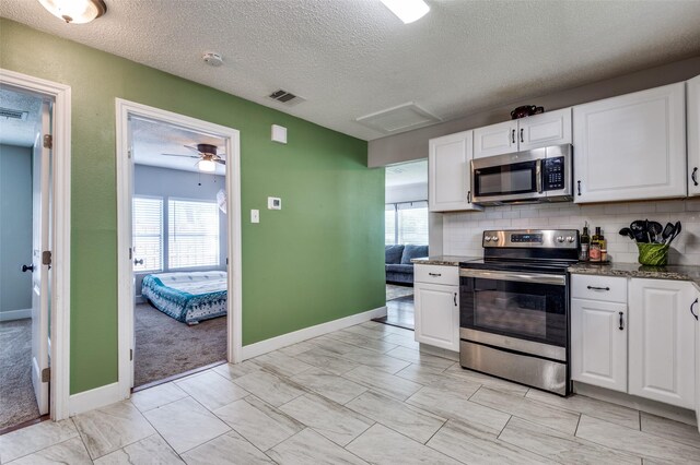 201 E Davis Ave, Alvarado, TX 76009 - kitchen featuring stainless steel appliances, white cabinetry, a textured ceiling, and healthy amount of natural light