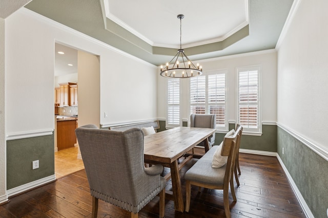 6044 Larkspur Ln, Frisco, TX 75036 - dining room with a chandelier, a tray ceiling, dark wood-style flooring, and crown molding