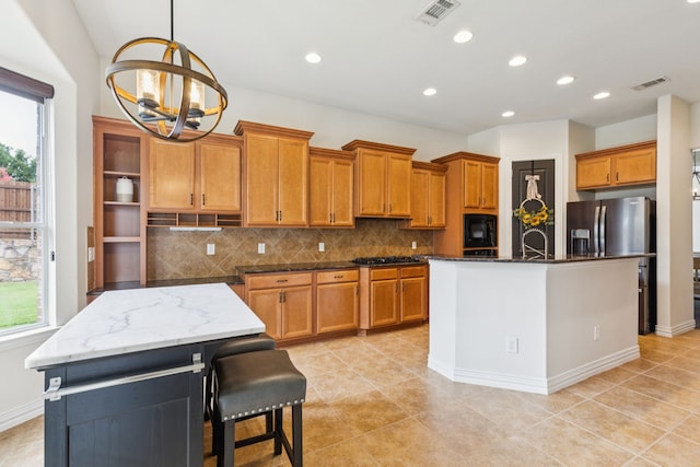 6044 Larkspur Ln, Frisco, TX 75036 - kitchen featuring an island with sink, brown cabinetry, a chandelier, tasteful backsplash, and recessed lighting