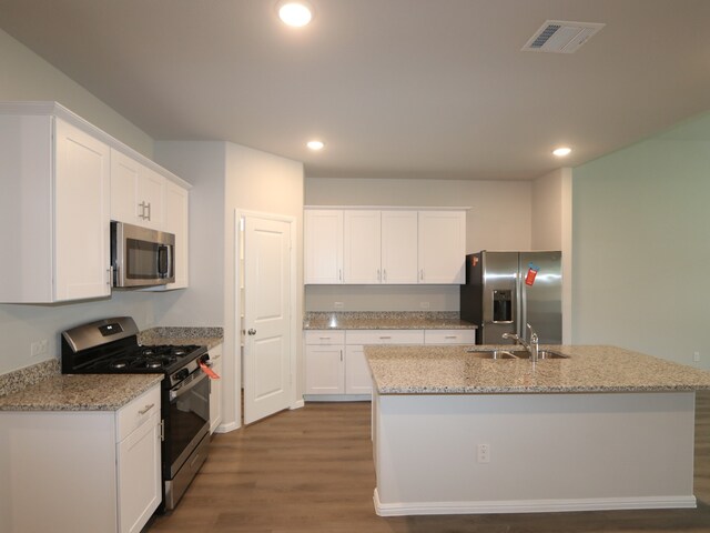 453 Forsyth Dr, Princeton, TX 75407 - kitchen with stainless steel appliances, dark wood-style flooring, an island with sink, white cabinets, and recessed lighting