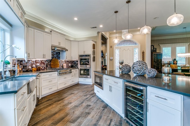 1600 Crockett Cir, Irving, TX 75038 - kitchen featuring wine cooler, stainless steel appliances, dark countertops, crown molding, and backsplash