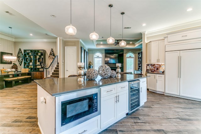 1600 Crockett Cir, Irving, TX 75038 - kitchen featuring wine cooler, built in appliances, ornamental molding, dark countertops, and light wood-type flooring