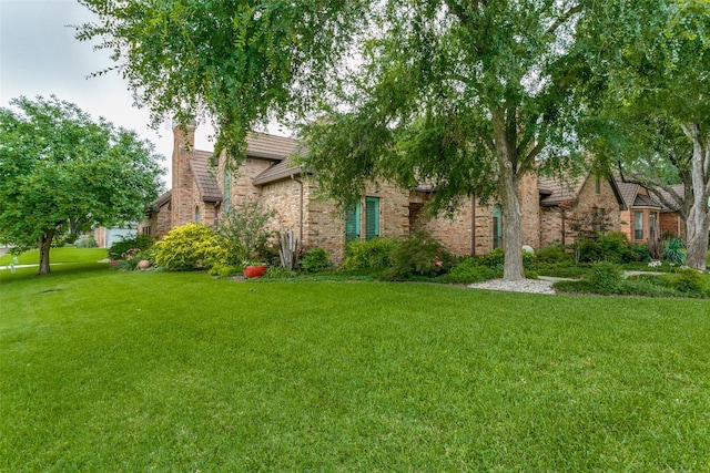 1600 Crockett Cir, Irving, TX 75038 - view of front of house with a front yard, a chimney, and brick siding