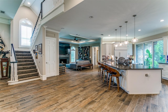 1600 Crockett Cir, Irving, TX 75038 - kitchen featuring ornamental molding, dark countertops, white cabinetry, wood finished floors, and a ceiling fan