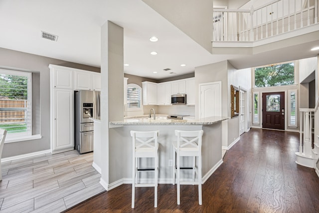 3805 Blaylock Pl, Plano, TX 75025 - kitchen featuring stainless steel appliances, light wood finished floors, light stone countertops, white cabinets, and recessed lighting