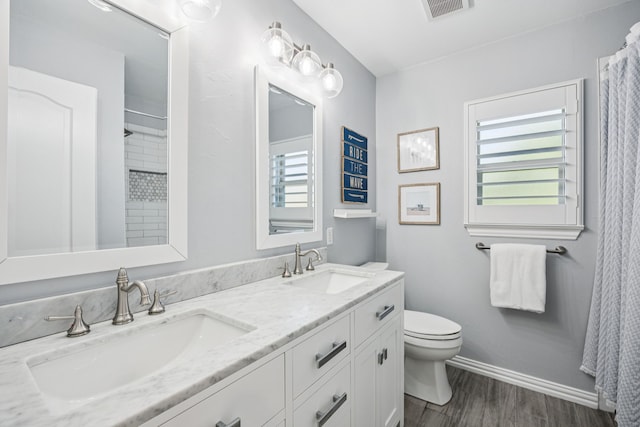 3805 Blaylock Pl, Plano, TX 75025 - bathroom featuring healthy amount of natural light, double vanity, wood finished floors, and a shower