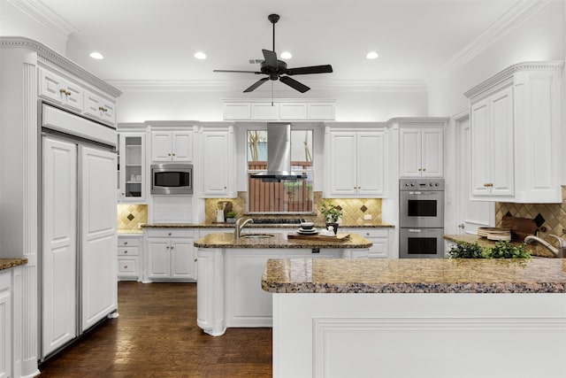 3928 Dove Creek Ln, Plano, TX 75093 - kitchen featuring wall chimney range hood, built in appliances, ceiling fan, decorative backsplash, and a peninsula