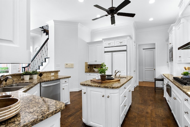3928 Dove Creek Ln, Plano, TX 75093 - kitchen with built in appliances, a kitchen island with sink, tasteful backsplash, ceiling fan, and crown molding