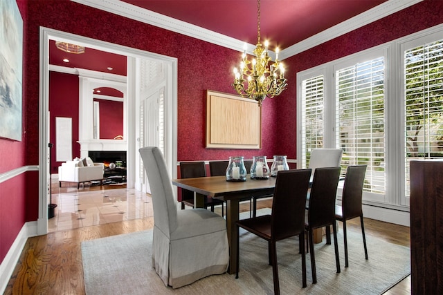 3928 Dove Creek Ln, Plano, TX 75093 - dining room with a chandelier, crown molding, a lit fireplace, and light wood-style flooring