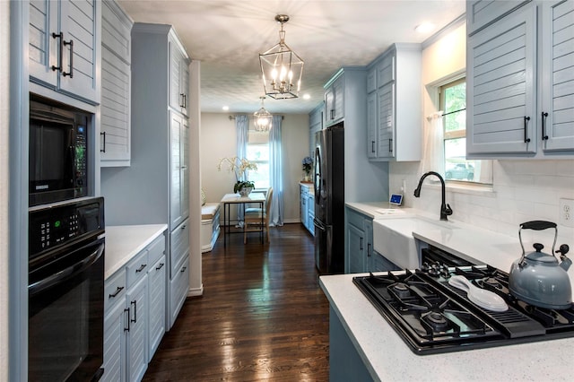 8803 Westglen Dr, Dallas, TX 75228 - kitchen with black appliances, a chandelier, backsplash, gray cabinetry, and hanging light fixtures